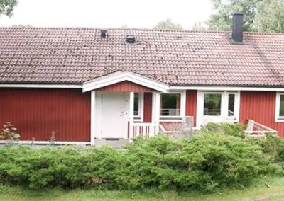 Långt rött hus med vita fönster, där lägenheten Örnen ligger