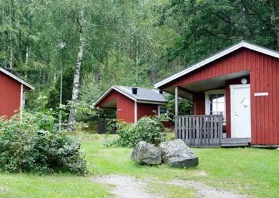 Röda stugor på en gräsmatta i skogen