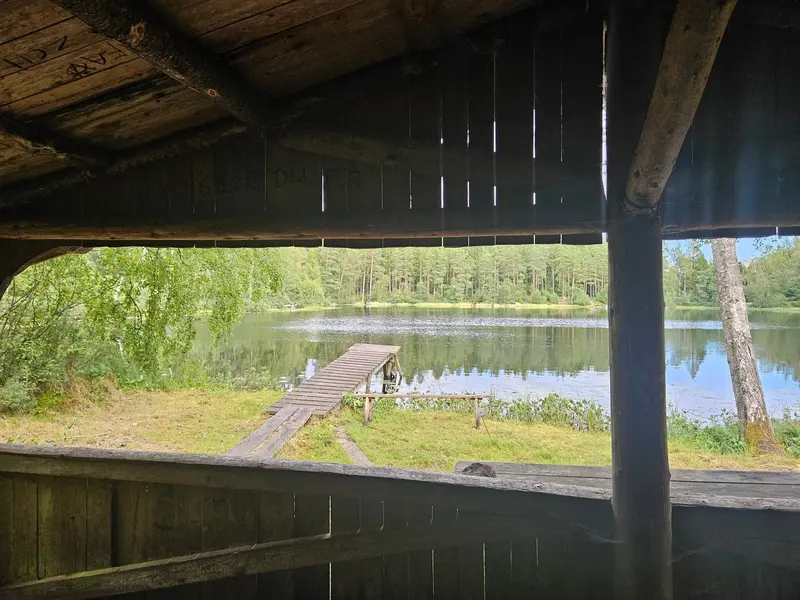 Utsikt från ett vindskydd mot en brygga och sjön